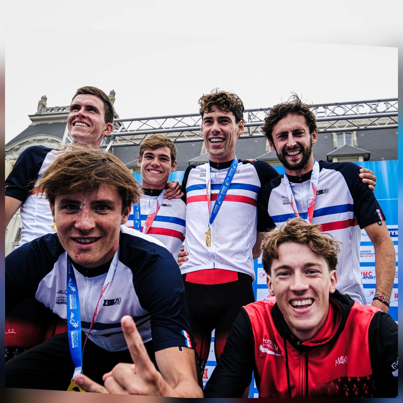 Athlètes en podium national de la Fédération Française de Triathlon, médailles au cou, avec un membre de Pontivy Triathlon